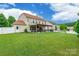Spacious backyard showcasing the home's exterior, a covered patio, and ample green space at 85017 Newloch Ct, Lancaster, SC 29720