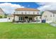 Wide shot of the home's back exterior and yard with a covered patio at 85017 Newloch Ct, Lancaster, SC 29720