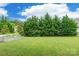 Expansive backyard with lush green grass, privacy trees, and a raised garden at 85017 Newloch Ct, Lancaster, SC 29720
