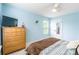 Sunny blue bedroom featuring light floors, dresser, and a sunlit window at 85017 Newloch Ct, Lancaster, SC 29720