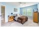 Airy blue bedroom with a plush rug, side tables, a dresser, and sunny windows at 85017 Newloch Ct, Lancaster, SC 29720