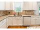 Clean and modern kitchen features stainless steel sink, granite countertop and sleek, white cabinetry at 85017 Newloch Ct, Lancaster, SC 29720