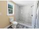 This bathroom features a shower with attractive marble-look tile at 921 W 1St St, Lowell, NC 28098