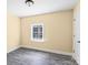 This is a bedroom with a window and a door. The room has gray wood-look floors at 921 W 1St St, Lowell, NC 28098