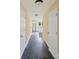 Hallway with white doors and gray flooring leading to a bright kitchen at 921 W 1St St, Lowell, NC 28098
