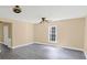 Bright living room with gray wood-look flooring, neutral walls, and a ceiling fan at 921 W 1St St, Lowell, NC 28098