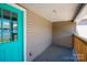 Covered porch with turquoise door, wood railing, and vinyl siding at 921 W 1St St, Lowell, NC 28098