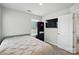Bedroom features a large window, TV, shelving, built in cabinet, and neutral tones at 1015 Maltby St, Charlotte, NC 28217