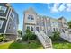Beautiful three-story townhome with gray siding, white trim, and a welcoming front entrance with landscaped yard at 1015 Maltby St, Charlotte, NC 28217
