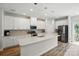 Modern kitchen with white cabinets, stainless steel appliances, a spacious island, and light wood flooring at 1015 Maltby St, Charlotte, NC 28217