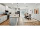 Well-lit kitchen with white cabinetry, stainless steel appliances, island, and an adjacent dining area at 1015 Maltby St, Charlotte, NC 28217