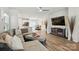 Open living area featuring a sectional sofa, hardwood floors, media center, and a combined dining and kitchen area at 1015 Maltby St, Charlotte, NC 28217