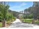 Long driveway lined with trees leads to brick home in wooded area at 102 Antioch Plantation Dr # 18, Matthews, NC 28104