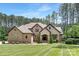 A brick-and-stone two-story home exhibits manicured lawn, mulched garden and tree-lined border at 102 Antioch Plantation Dr # 18, Matthews, NC 28104