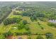 Expansive aerial view of a lush property featuring open fields, mature trees, a serene pond, and outbuildings at 1081 Long Dr, Newton, NC 28658