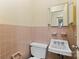 Compact bathroom featuring pink tile, a sink, and a toilet, offering functionality in a cozy space at 1081 Long Dr, Newton, NC 28658
