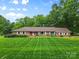 Inviting brick home with neatly manicured lawn, mature trees, and established landscaping at 1081 Long Dr, Newton, NC 28658