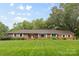 Charming brick home with a well-manicured lawn, mature trees, and a welcoming front entrance at 1081 Long Dr, Newton, NC 28658