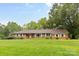 Charming brick ranch home on a lush green lawn with mature trees and manicured landscaping at 1081 Long Dr, Newton, NC 28658