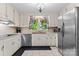 Updated kitchen with stainless steel appliances, white cabinetry, and a view of the backyard at 1081 Long Dr, Newton, NC 28658