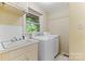 Well-lit laundry room featuring a sink, washer, and dryer for convenience and efficiency at 1081 Long Dr, Newton, NC 28658