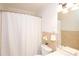 Cozy bathroom featuring a shower with a white curtain, neutral tile, and a decorative flower at 10945 Winterbourne Ct, Charlotte, NC 28277