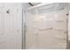 White tile shower stall with seat and glass door at 10945 Winterbourne Ct, Charlotte, NC 28277