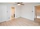 Bedroom with light-colored laminate floors, a ceiling fan, closet, and an ensuite bath at 10945 Winterbourne Ct, Charlotte, NC 28277