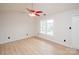 Bright bedroom with light wood floors, ceiling fan, and large windows offering ample natural light at 10945 Winterbourne Ct, Charlotte, NC 28277