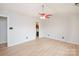 Spacious bedroom with light hardwood floors, a ceiling fan, and a glimpse into an adjacent bathroom at 10945 Winterbourne Ct, Charlotte, NC 28277