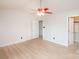 Bright bedroom featuring light wood floors, ceiling fan, and doors to the closet and hallway at 10945 Winterbourne Ct, Charlotte, NC 28277