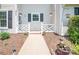 Close-up of home entrance; white fence, manicured flower beds, and inviting pathway at 10945 Winterbourne Ct, Charlotte, NC 28277
