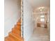 Bright hallway featuring hardwood stairs, neutral walls, and tiled floor leading to a cozy living area at 10945 Winterbourne Ct, Charlotte, NC 28277