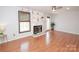 Bright living room boasts hardwood floors, a fireplace, and large window providing natural light at 10945 Winterbourne Ct, Charlotte, NC 28277