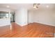 Open-concept living room with hardwood floors, fresh paint, and a view of the adjacent kitchen at 10945 Winterbourne Ct, Charlotte, NC 28277