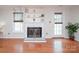 Bright living room with hardwood floors, a white brick fireplace, built-in shelving, and a door to the backyard at 10945 Winterbourne Ct, Charlotte, NC 28277