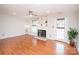 Open living room with a fan, hardwood floors, fireplace, built-in shelving and a door with windows at 10945 Winterbourne Ct, Charlotte, NC 28277