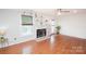 Spacious living room featuring hardwood floors, a fireplace with built-in shelving, and lots of natural light at 10945 Winterbourne Ct, Charlotte, NC 28277