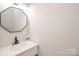 Modern powder room featuring a vanity with a black faucet and a decorative mirror at 10945 Winterbourne Ct, Charlotte, NC 28277