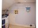 Compact utility area features pale walls with shelves and beige floors with appliances at 10945 Winterbourne Ct, Charlotte, NC 28277