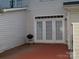 An outdoor patio is highlighted by the double french doors, grill, and neutral siding at 11107 Lions Mane St, Charlotte, NC 28273