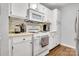 Well-equipped kitchen with white appliances, tile backsplash, and plenty of cabinet storage at 124 Cedarcroft Dr, Mooresville, NC 28115