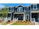 Charming two-story townhouse with blue siding, white trim, and manicured landscaping at 124 Utility Ln # E, Mooresville, NC 28117