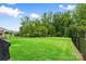 Expansive backyard with lush green grass, surrounded by mature trees and a black metal fence at 12637 Belmont Mansion Dr, Charlotte, NC 28273