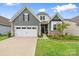 Charming home boasts a two-car garage, landscaped lawn, and stylish green siding with stone accents at 12637 Belmont Mansion Dr, Charlotte, NC 28273