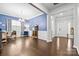 Open office with blue accent wall, white trim, hardwood floors, and view into entryway at 12637 Belmont Mansion Dr, Charlotte, NC 28273