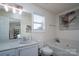 Bright bathroom with a bathtub, single vanity, and boat artwork on the wall at 12719 Walking Stick Dr, Charlotte, NC 28278
