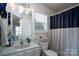 Bright bathroom with a spacious vanity, ample lighting, and decorative curtain for a comfortable, modern space at 12719 Walking Stick Dr, Charlotte, NC 28278