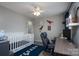 Playful bedroom with a crib, desk, and creative decor creating an inspiring, fun, and bright area at 12719 Walking Stick Dr, Charlotte, NC 28278