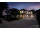 Well-lit home exterior at twilight featuring a spacious driveway and manicured lawn at 12719 Walking Stick Dr, Charlotte, NC 28278